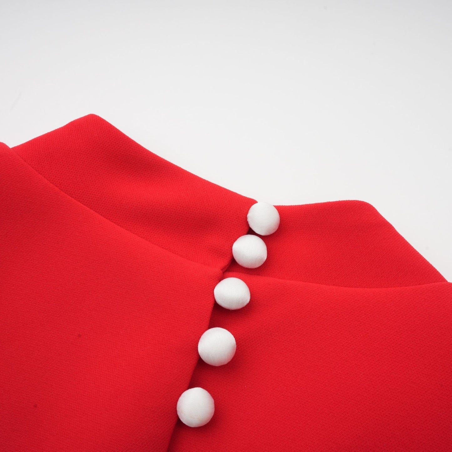 Young woman wearing a red mini dress with petal sleeves and cutout detail featuring a bow accent
