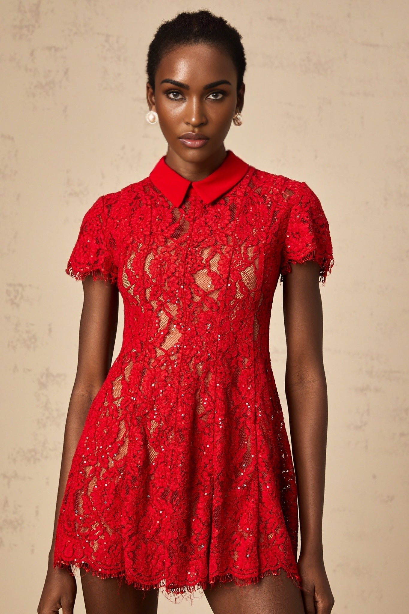 Young woman wearing a short red dress with sequin and lace details