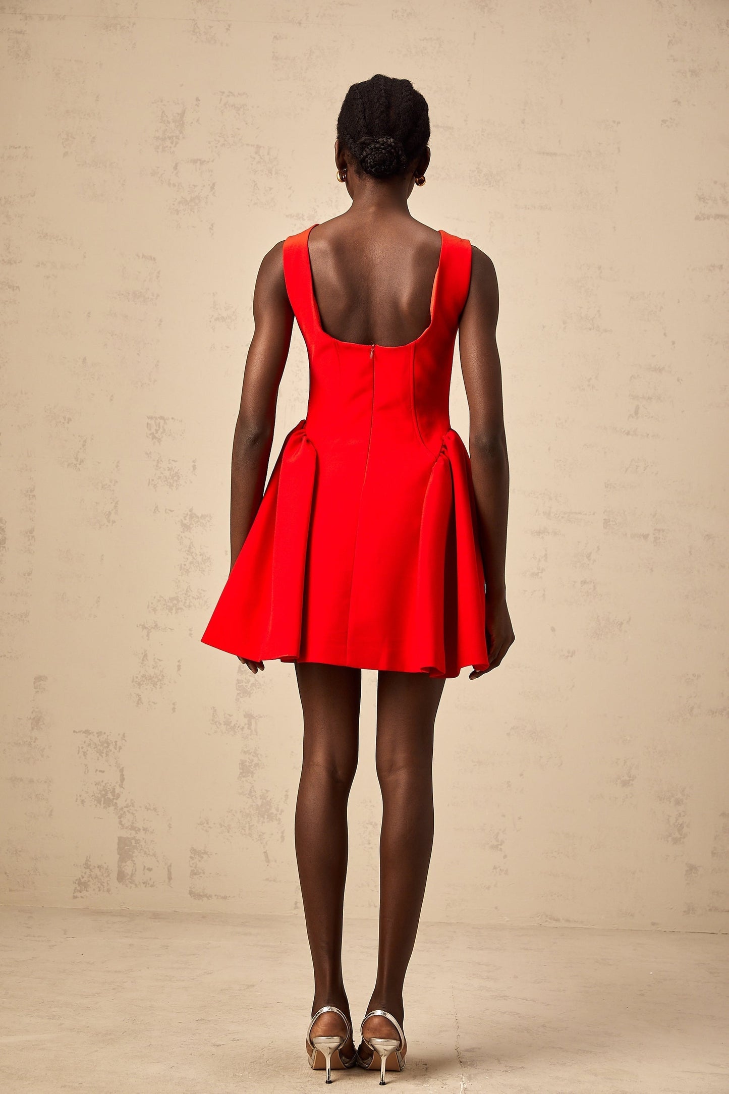 Young woman wearing a vibrant red sleeveless mini dress with a flared skirt