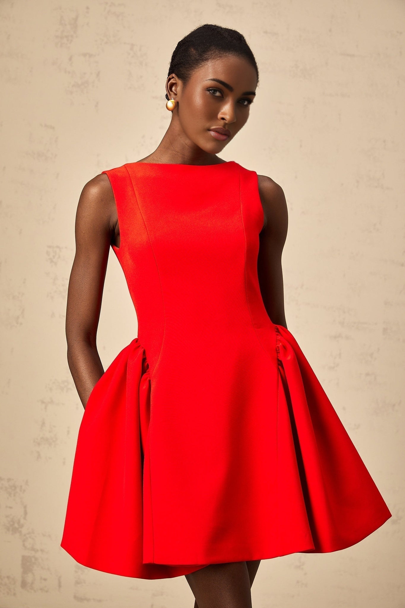 Young woman wearing a vibrant red sleeveless mini dress with a flared skirt