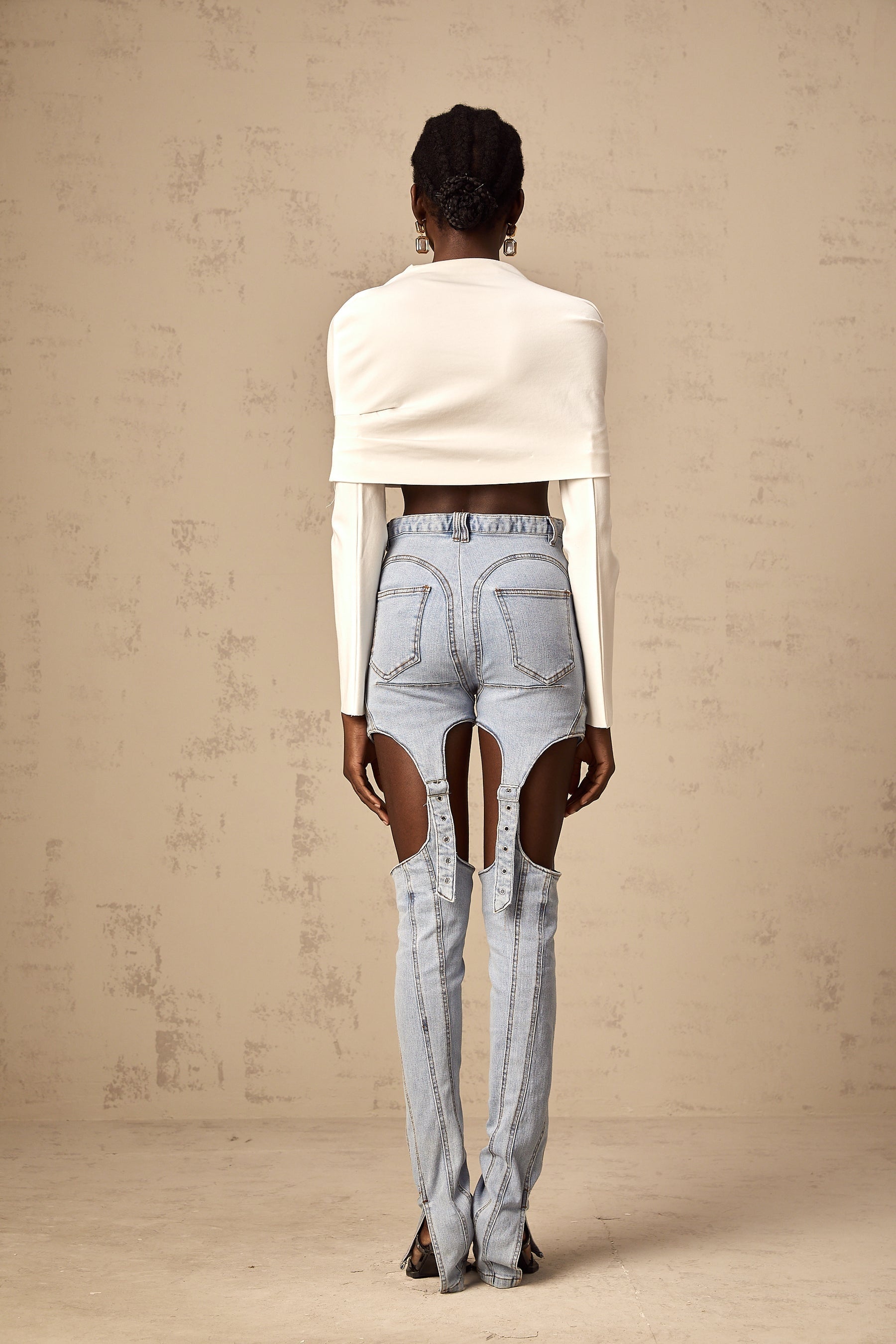 Young woman wearing a white cropped top with ruched detailing and short sleeves