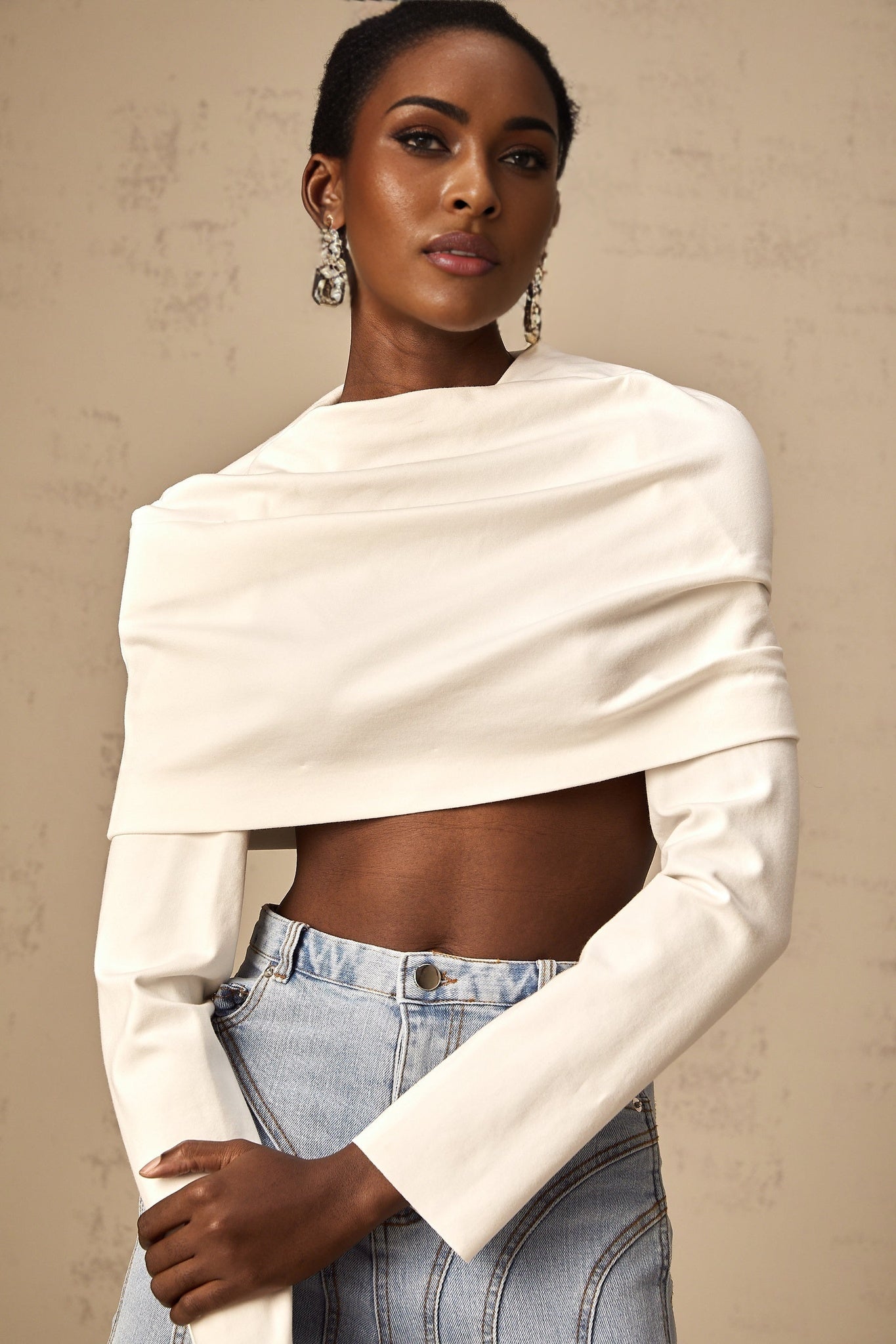 Young woman wearing a white cropped top with ruched detailing on the front and short sleeves