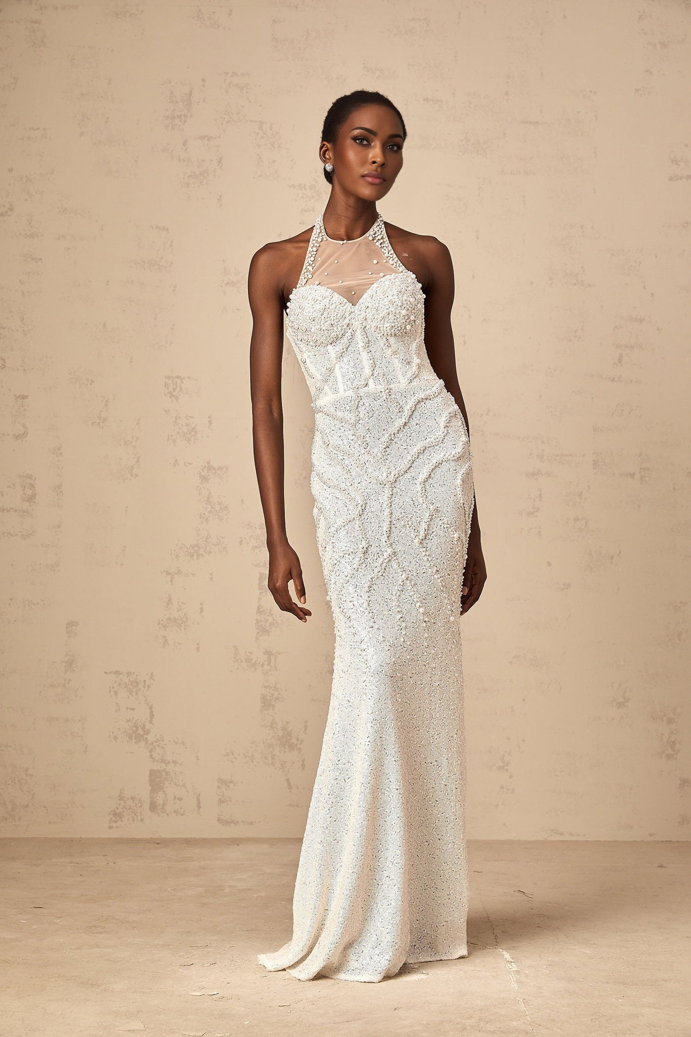 Young woman wearing long white maxi dress with faux pearl embellishments