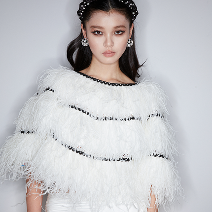 Sophia feather-embellished cape with tiered ostrich feathers, black trim accents, and a relaxed fit, crafted from lightweight polyester.
