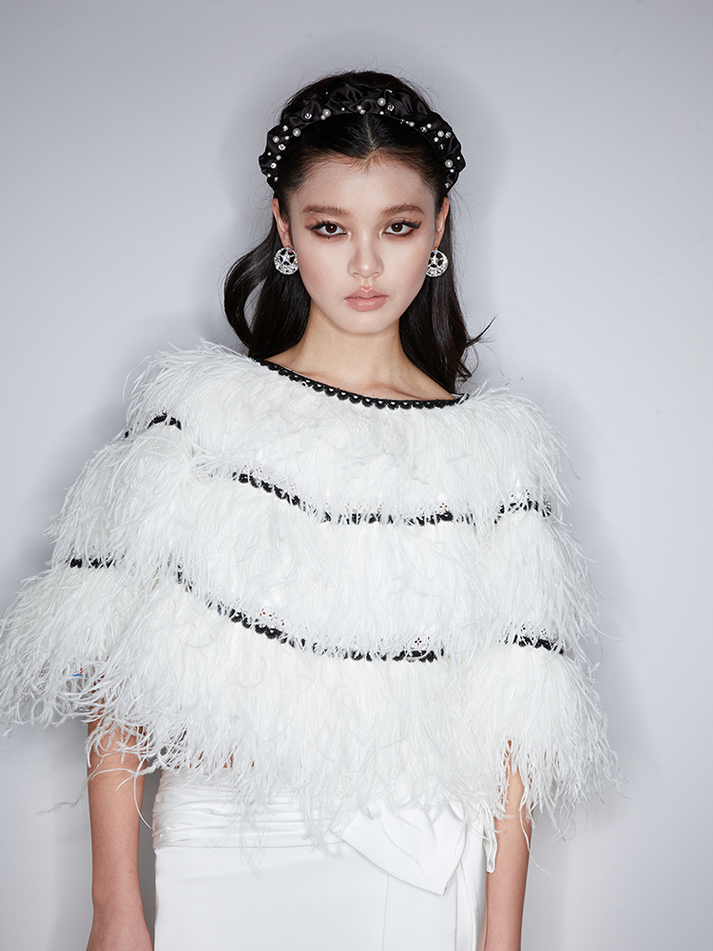 Sophia feather-embellished cape with tiered ostrich feathers, black trim accents, and a relaxed fit, crafted from lightweight polyester.