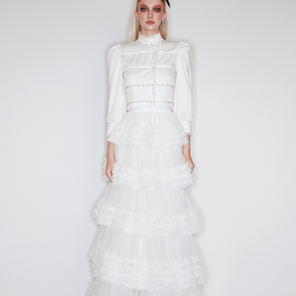 Sophia lace-embellished blouse with a high neckline, intricate lace detailing, puffed sleeves, and tailored fit, crafted from cotton, nylon, and spandex.