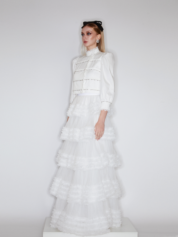 Sophia lace-embellished blouse with a high neckline, intricate lace detailing, puffed sleeves, and tailored fit, crafted from cotton, nylon, and spandex.