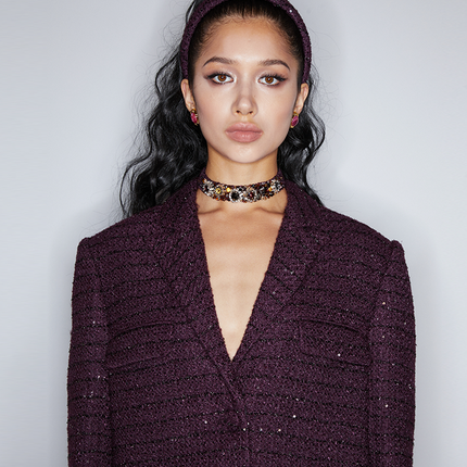 Longline tweed blazer with a tailored silhouette, functional pockets, and a wool-blend fabric. Made from 94.3% polyester fiber, 5.7% sheep wool, and lined with 100% polyester