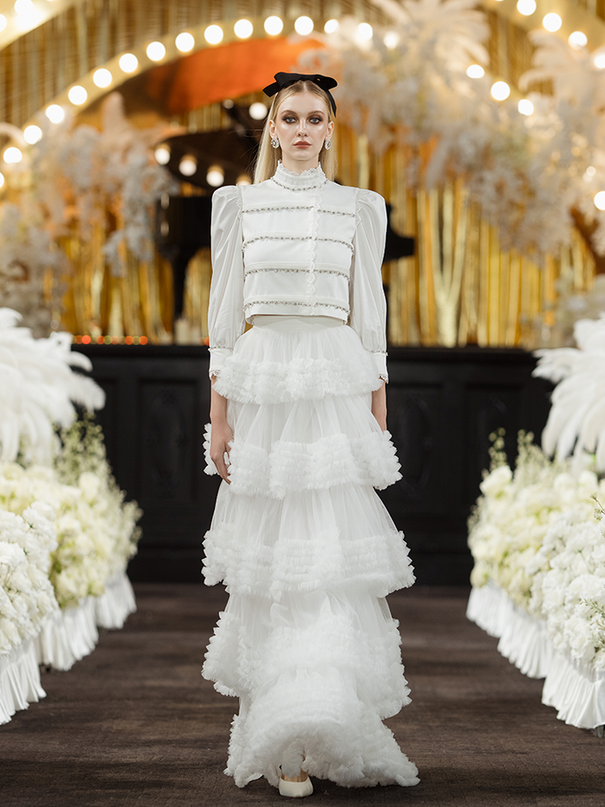 Sophia lace-embellished blouse with a high neckline, intricate lace detailing, puffed sleeves, and tailored fit, crafted from cotton, nylon, and spandex.