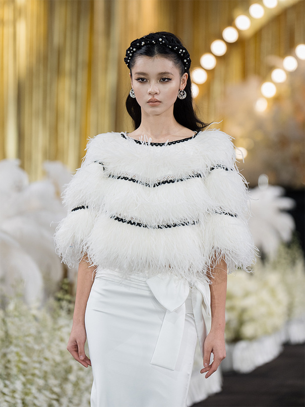 Sophia asymmetric white evening dress with a delicate bow detail, flowing silhouette, and layered hemline, crafted from lightweight polyester.