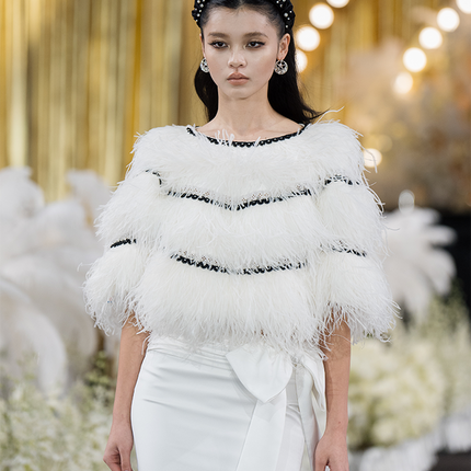 Sophia feather-embellished cape with tiered ostrich feathers, black trim accents, and a relaxed fit, crafted from lightweight polyester.