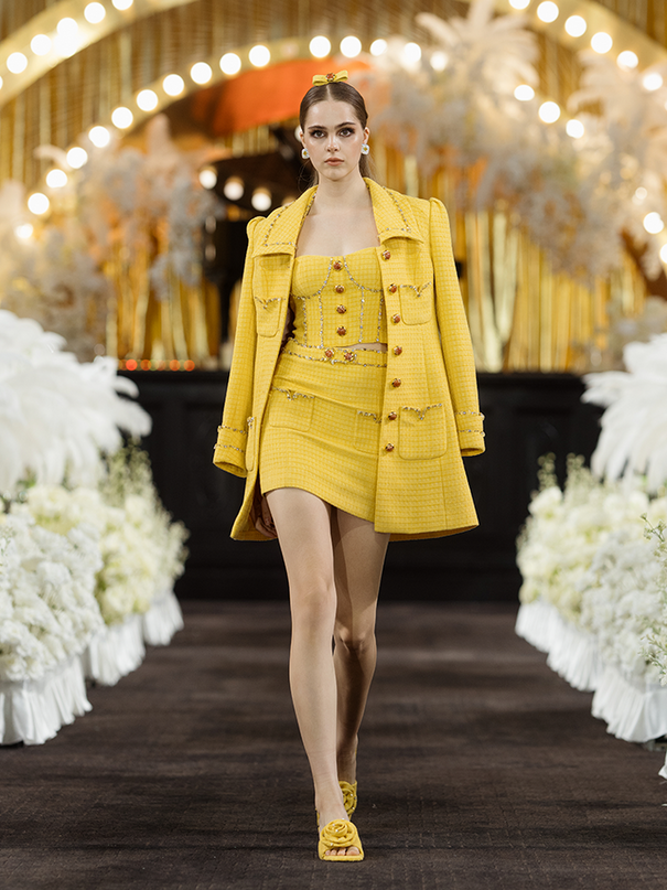 Sophia embellished tweed mini skirt in vibrant yellow with a high-waisted fit, crystal embellishments, gemstone belt, and front pocket details, crafted from 100% polyester.