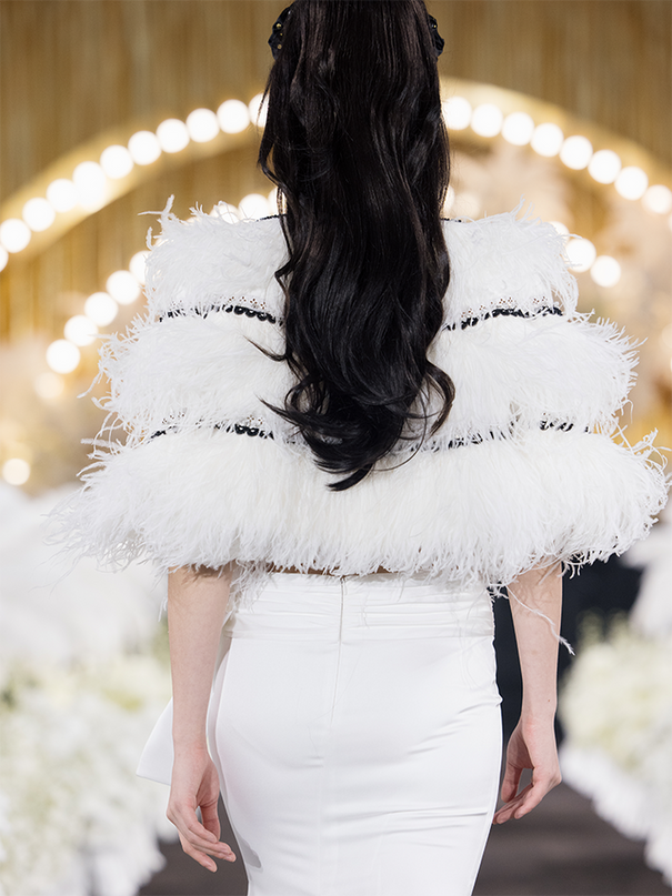 Sophia feather-embellished cape with tiered ostrich feathers, black trim accents, and a relaxed fit, crafted from lightweight polyester.