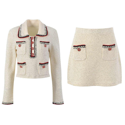 Elegant cream tweed jacket with red and black embroidery, decorative buttons, and a tailored fit