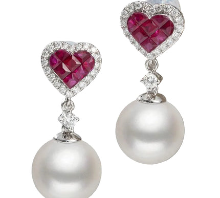 Pair of earrings with heart-shaped rubies and pearl drops on a white background