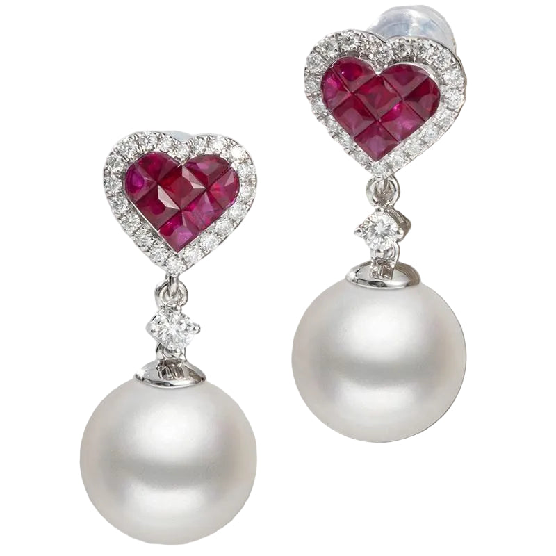 Pair of earrings with heart-shaped rubies and pearl drops on a white background
