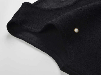 Sleeveless black mini dress featuring delicate pearl embellishments and a playful tiered ruffle skirt