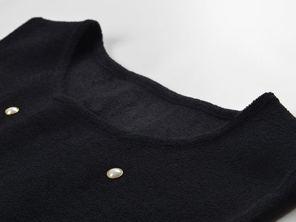 Sleeveless black mini dress featuring delicate pearl embellishments and a playful tiered ruffle skirt