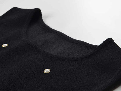 Sleeveless black mini dress featuring delicate pearl embellishments and a playful tiered ruffle skirt