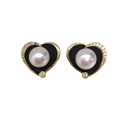 Heart-shaped earrings with pearls and black enameled borders on a white background