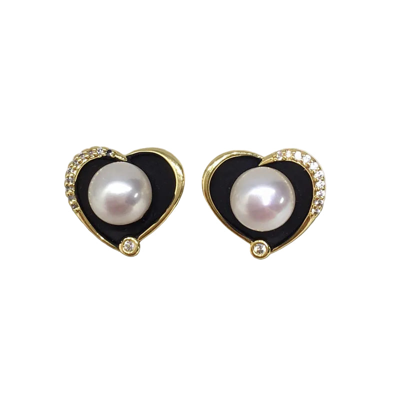 Heart-shaped earrings with pearls and black enameled borders on a white background