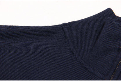 Navy bomber jacket featuring denim patch pockets, a full front zipper, smocked waistband, cuffs, and decorative gold-tone buttons