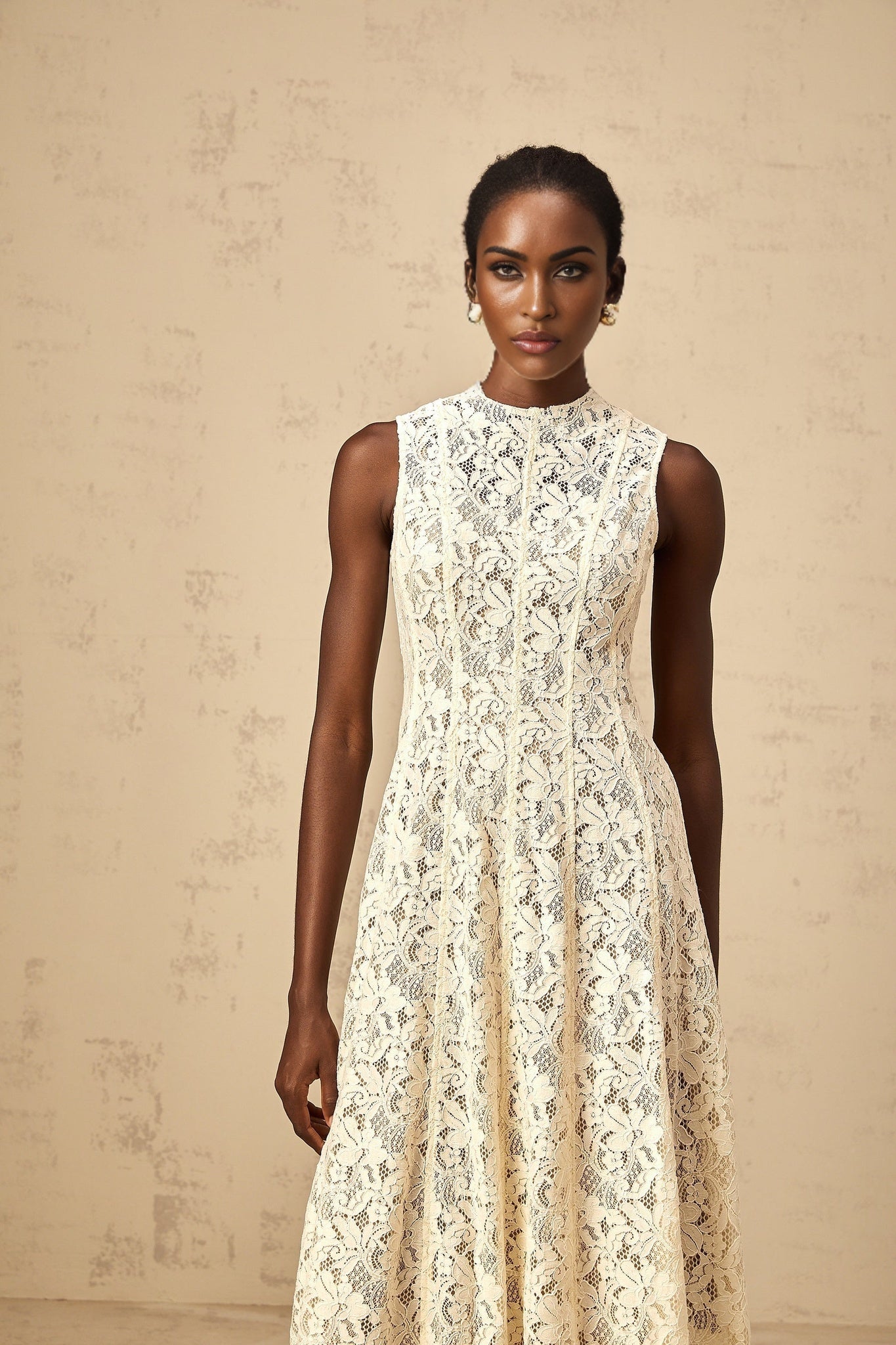 A beige midi dress with floral lace pattern and flared skirt design called Edelie