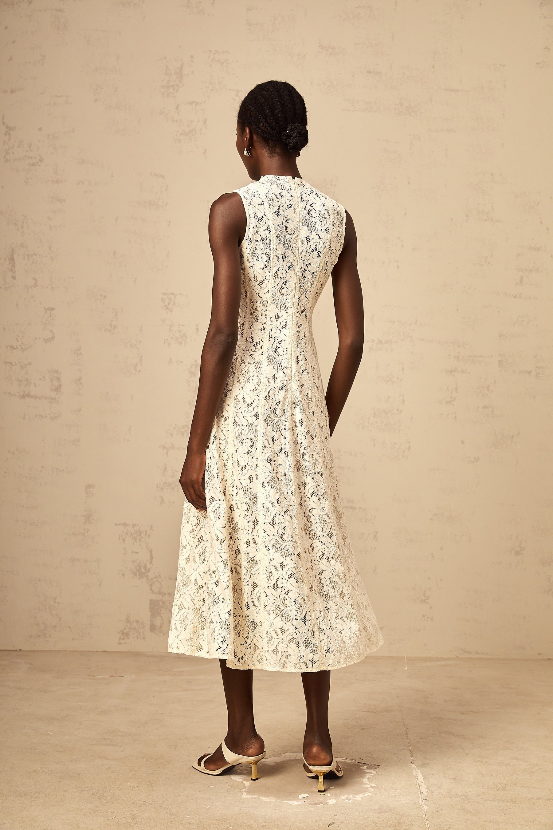 A beige midi dress with floral lace pattern and flared skirt design