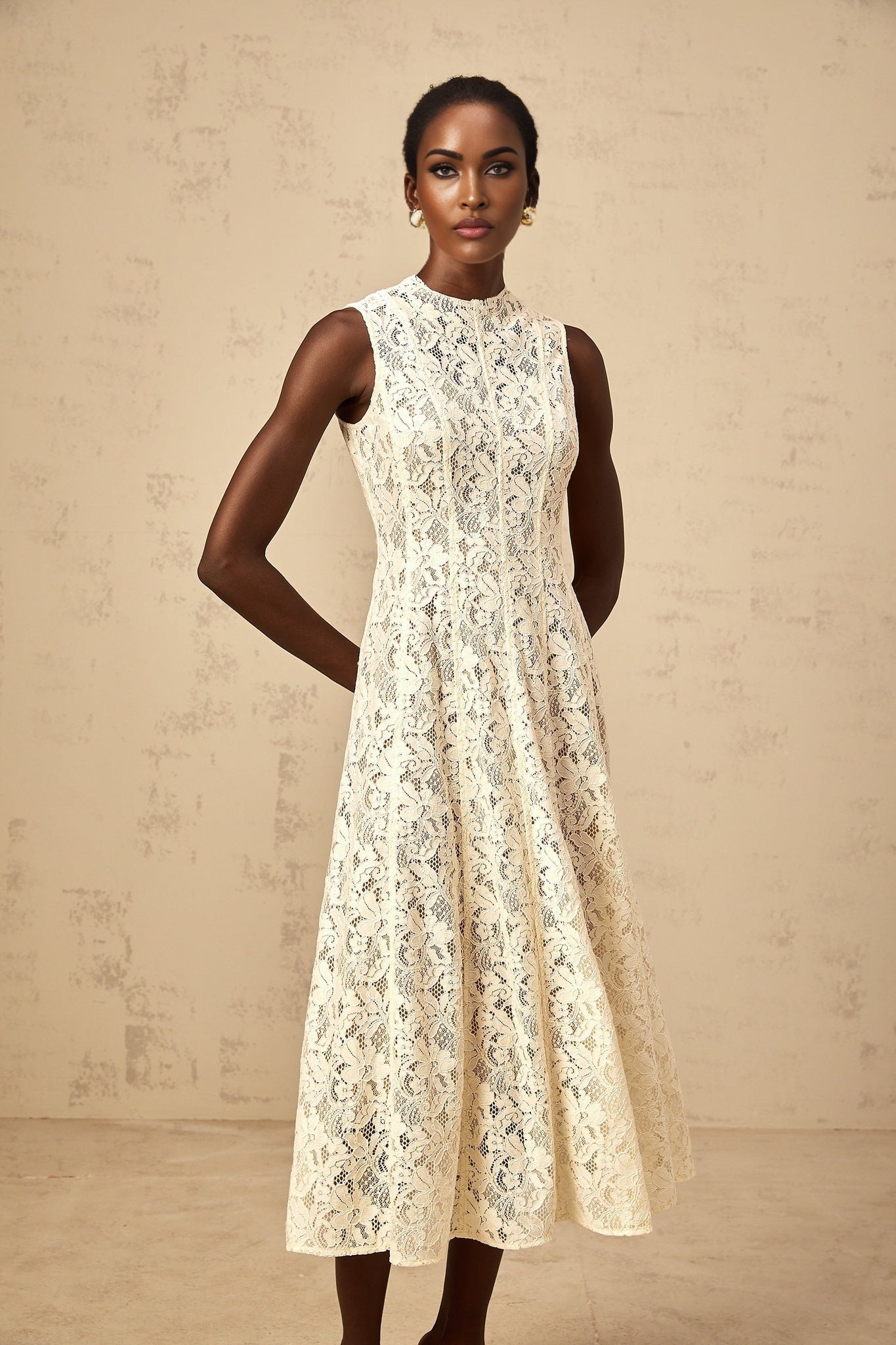 A beige midi dress with floral lace pattern and flared skirt on a plain background