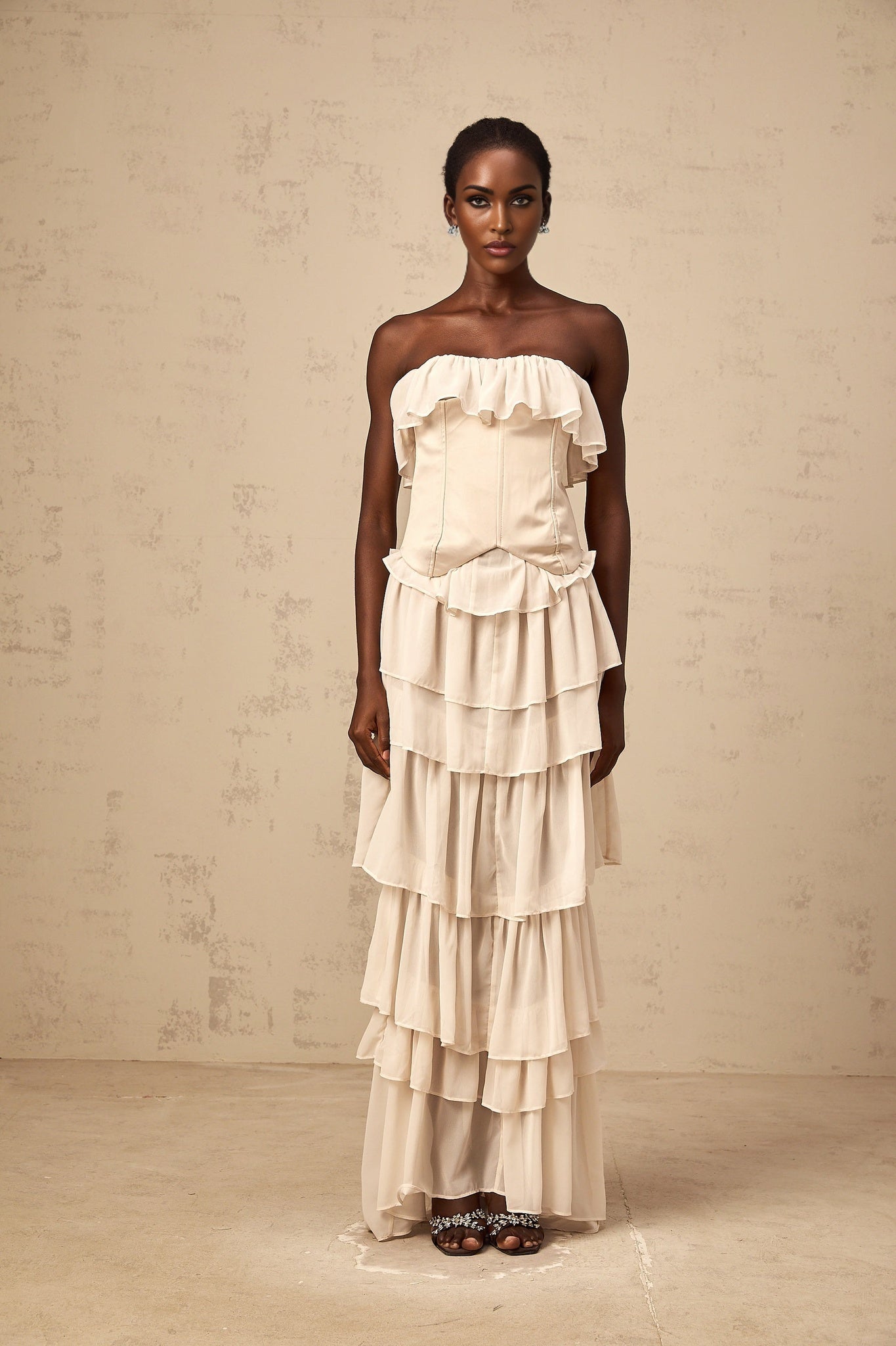 A beige offshoulder dress and corset set featuring a tiered skirt and matching corset top in a light neutral color