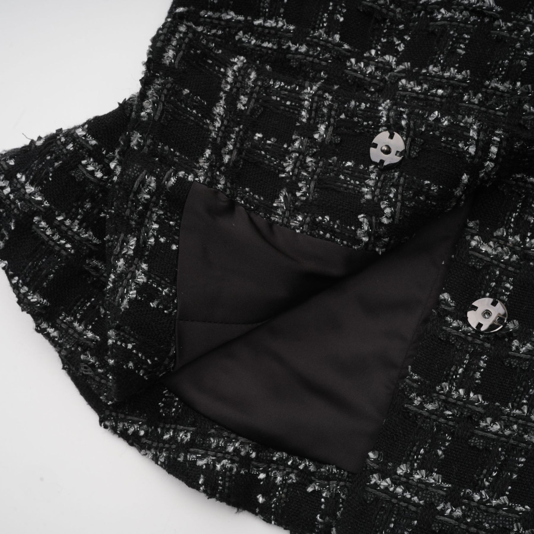 A black and white checked tweed matching set consisting of a sleeveless vest top and skirt in a classic pattern