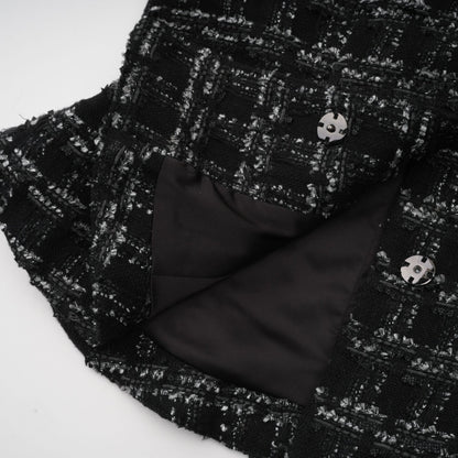A black and white checked tweed matching set consisting of a sleeveless vest top and skirt in a classic pattern