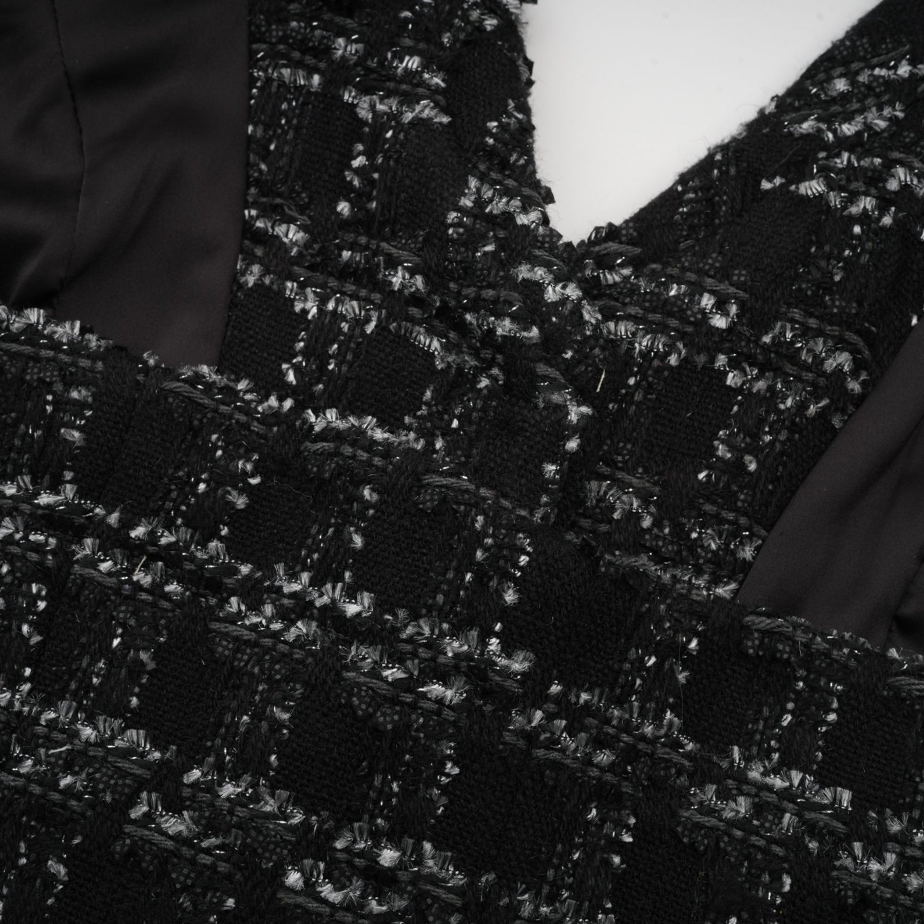 A black and white checked tweed matching set featuring a sleeveless vest top and skirt in a classic pattern