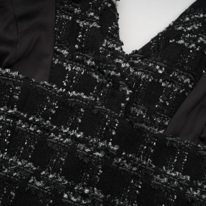 A black and white checked tweed matching set featuring a sleeveless vest top and skirt in a classic pattern