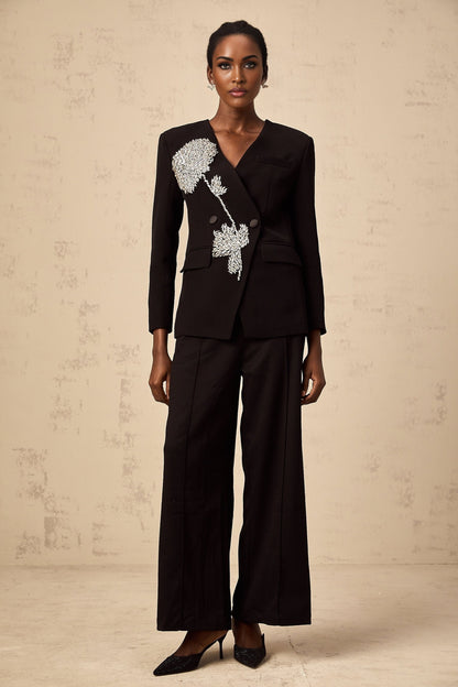 A black blazer adorned with floral embellishments featuring a flower motif design named Therese