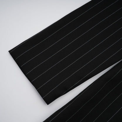 A black blazer with white stripes featuring an open back design modeled on a person