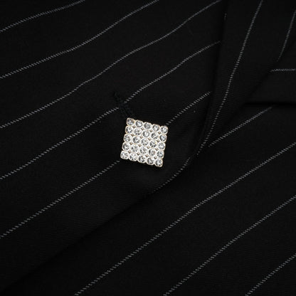 A black blazer with white stripes featuring an open back design worn by a model