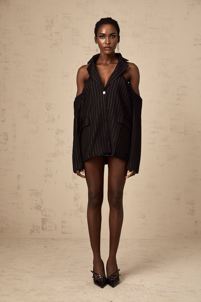 A black blazer with white stripes featuring an open back design worn by a model
