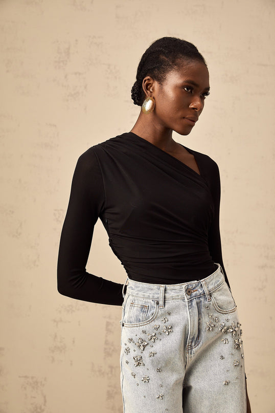 A black bodysuit with an asymmetric split design featuring a unique cut named Fachtna