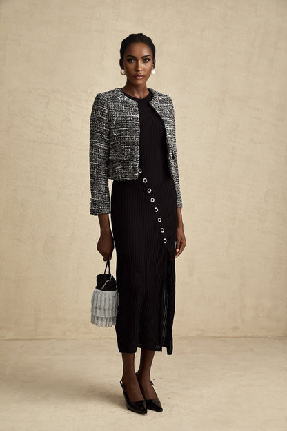 A black bouclé tweed jacket with a classic design featuring textured fabric and a tailored silhouette