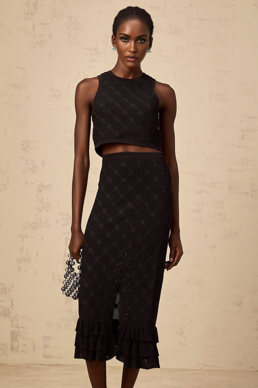 A black crochet knit matching set featuring a top and skirt Joelle design with intricate pattern details and textured fabric