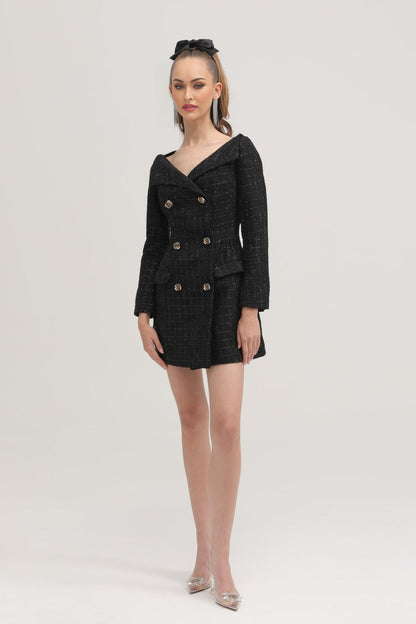 A black doublebreasted coat dress named Erin worn by a model against a plain background