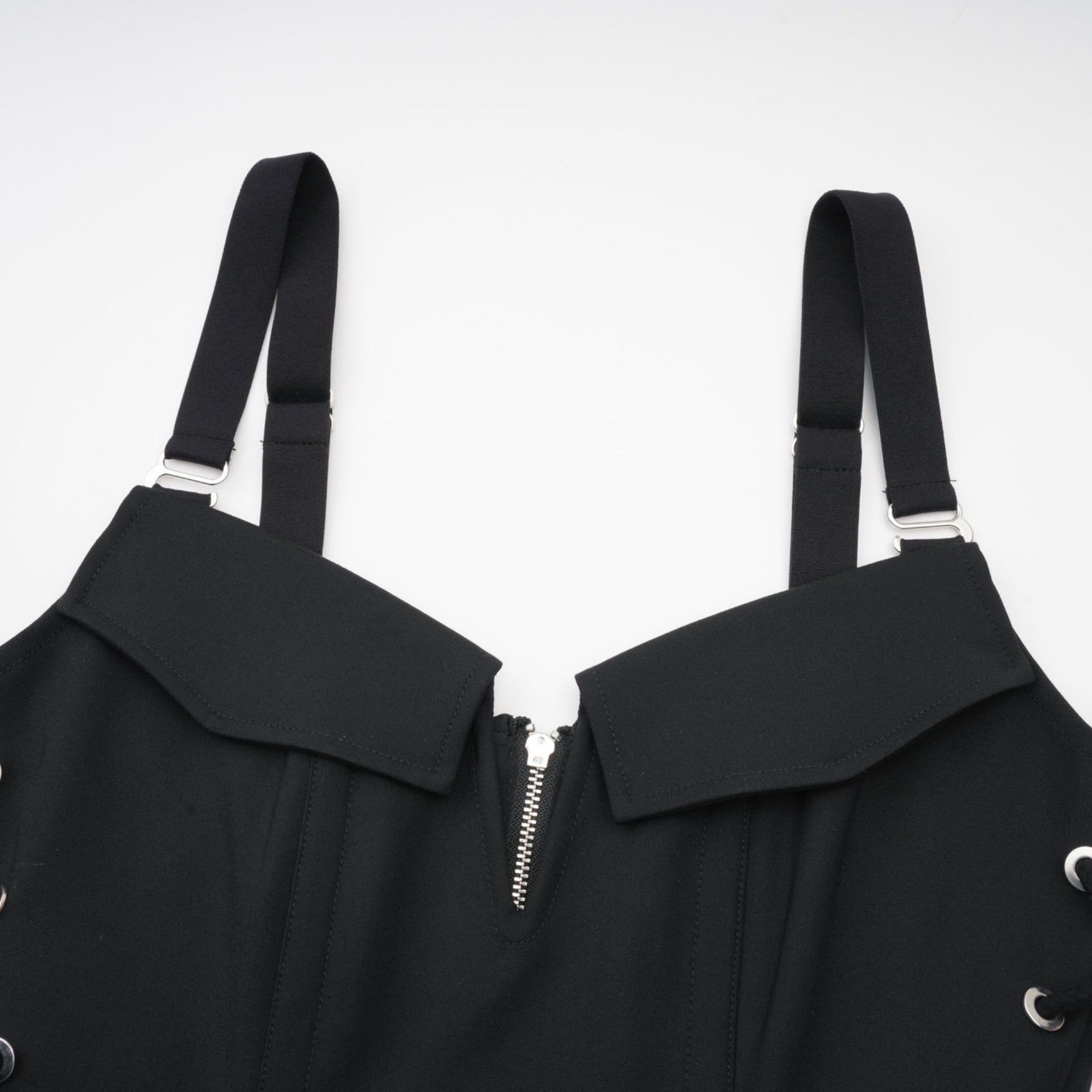 Sleeveless black dress with Vneck boned bodice adjustable straps rear zip hook closure flap pockets thighlength 98% Organic Cotton 2% Elastane