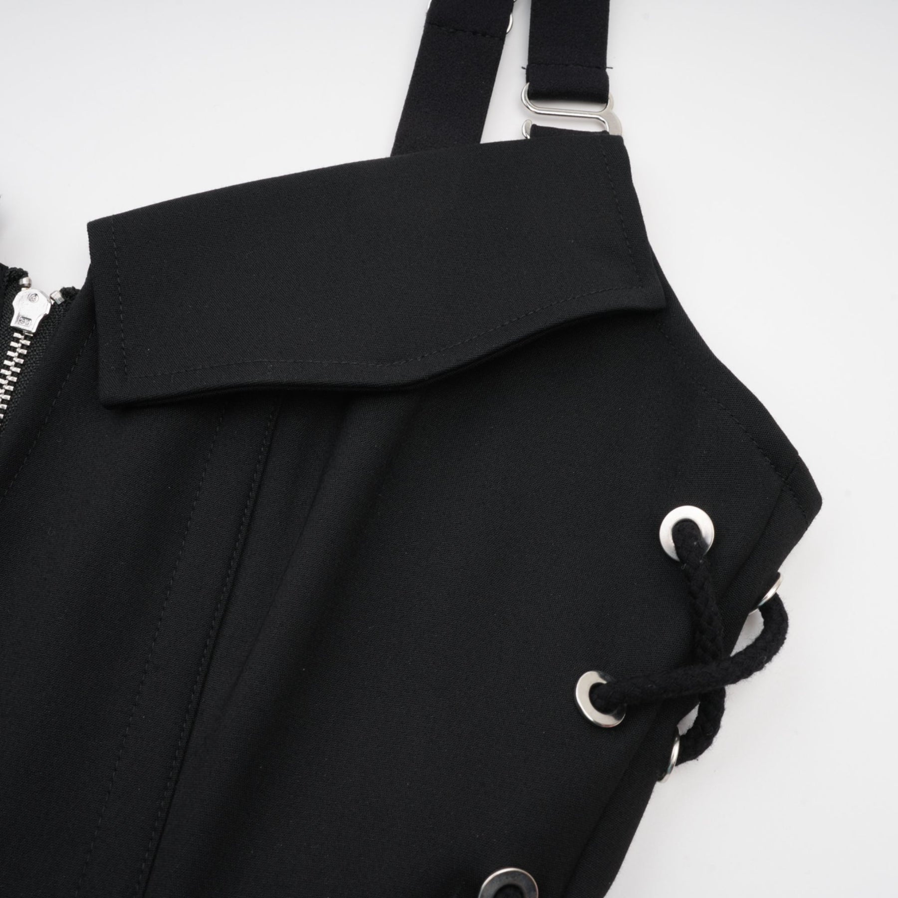 Black sleeveless dress with a Vneck and structured boned bodice Adjustable and detachable shoulder straps stylish chest flap pockets and thighlength coverage Made of 98% Organic Cotton and 2% Elastane Wrapped in designer rear zip and side hook and eye closure