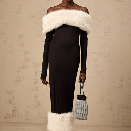 A black faux fur midi dress with an offshoulder neckline worn by a model standing against a plain background