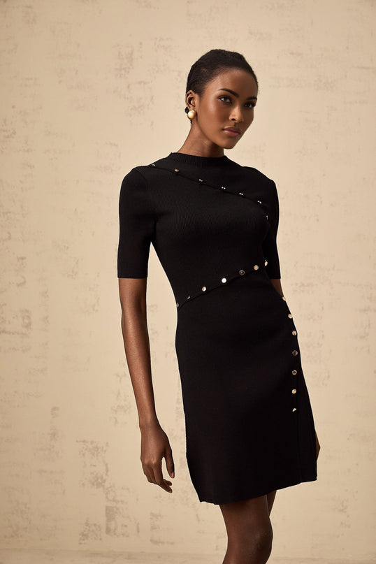 A black fineknit mini dress with decorative buttons named Wanda on a plain background