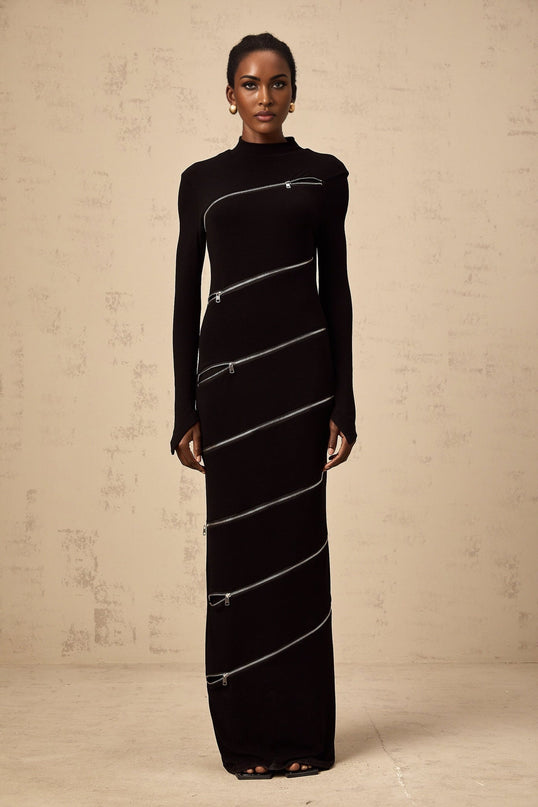 A black fitted maxi dress with zippered details and a long silhouette named Costanza