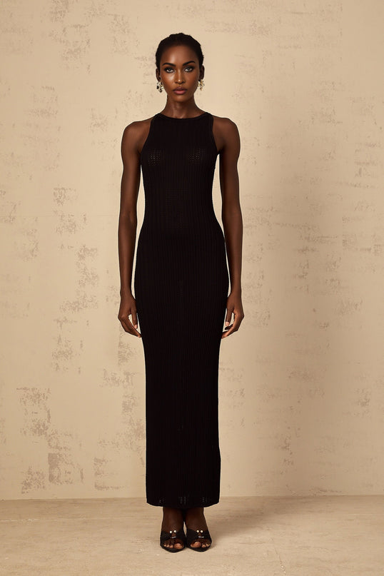 A black fitted ribbed knit maxi dress with long sleeves and a form fitting silhouette