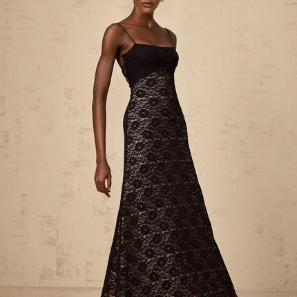 A black floor length maxi dress with an open back design and intricate floral lace detailing throughout the garment