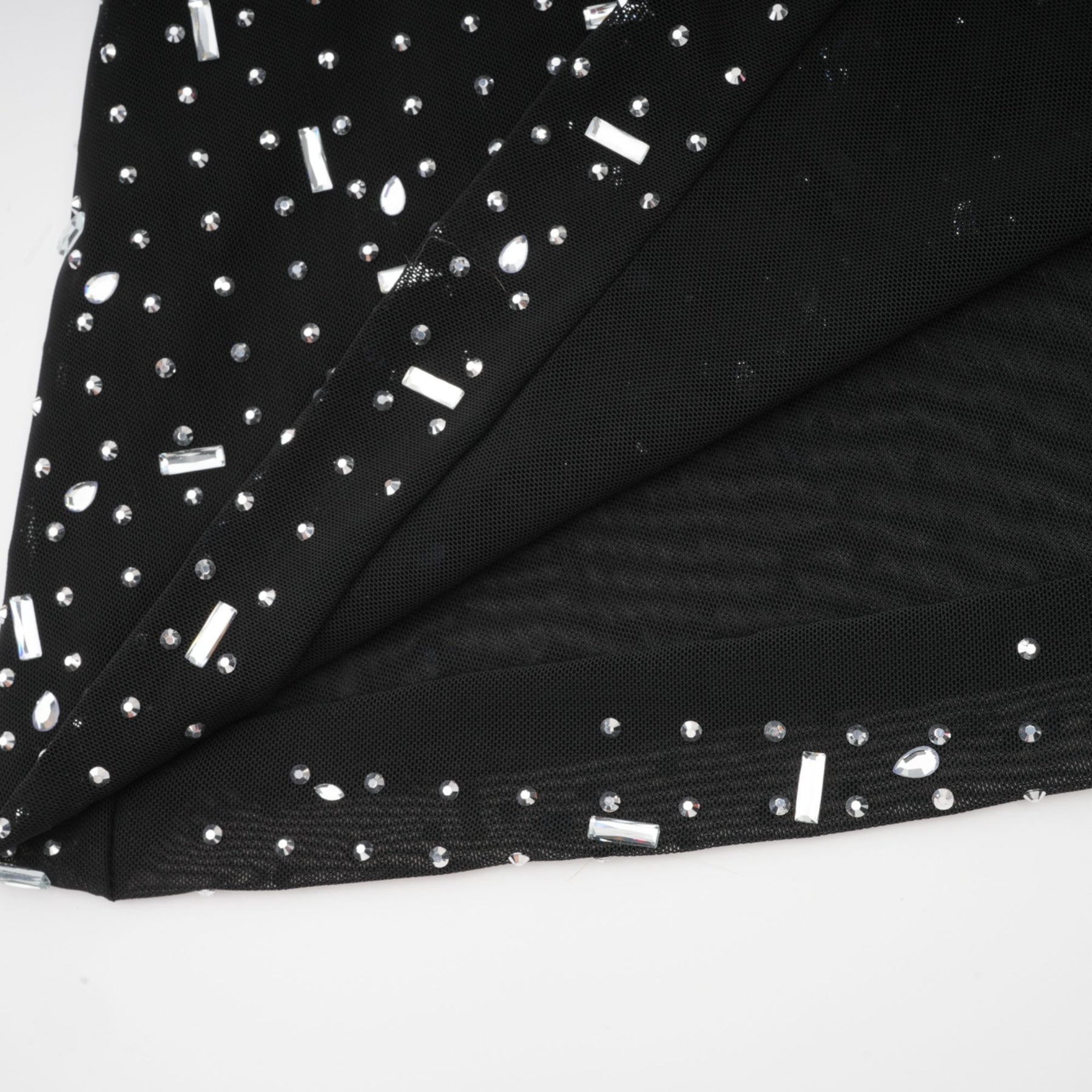 A black floor length maxi dress with sheer fabric and embellished details worn by a model